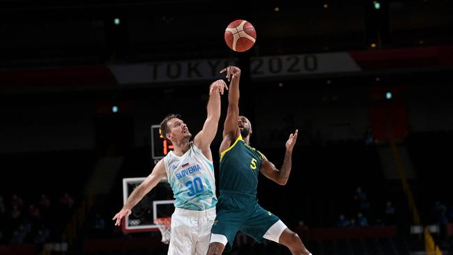 Australia's Patty Mills (R) takes a shot past Slovenia's Zoran Dragic. Picture: Aris Messinis/AFP