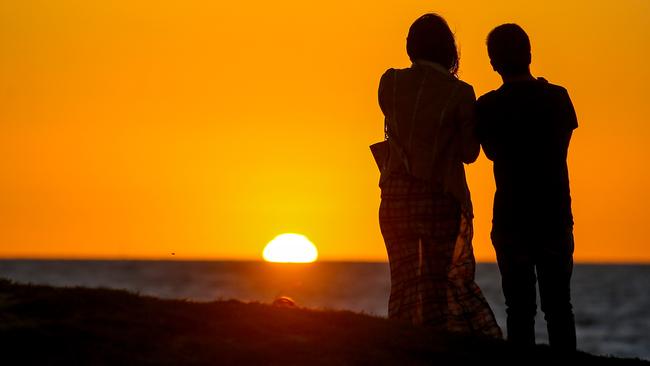Melburnians watch the sunset on New Year’s Eve at St Kilda Beach. Picture: Martin Keep