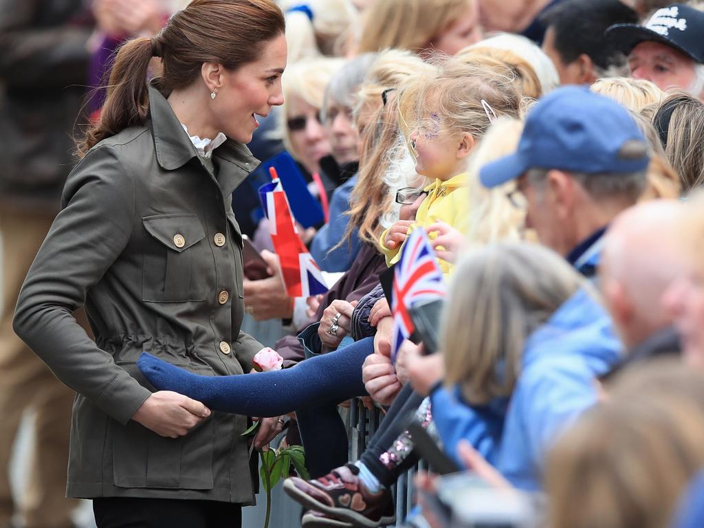 The casually dressed Duchess of Cambridge playfully grabbed the foot of Pearl Walker, 3, in the town centre during a visit to the Lake District. Picture: Peter Byrne/PA Wire