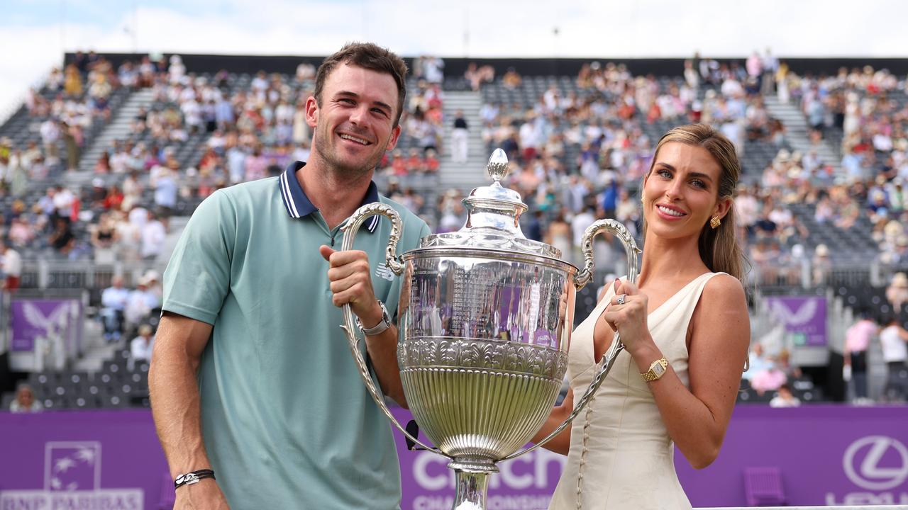 Tommy Paul and girlfriend, Paige Lorenze pose for a photo with the trophy after winning the singles title at Queen’s. (Photo by Clive Brunskill/Getty Images)