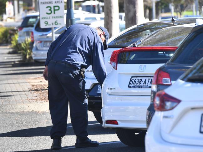 A parking Inspector with chalk photographed on Anzac Highway at Glenelg, Adelaide on Monday the 30th of April 2018. A new system has been trialled for people parking at Glenelg, with Council camera's recording a cars number plate, instead of the old chalk on tyre system. (AAP/ Keryn Stevens)