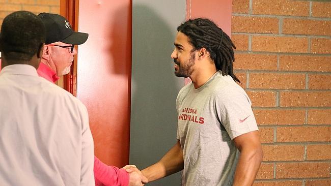 The Arizona Cardinals have signed former Gold Coast Suns player Joel Wilkinson, right, pictured being welcomed by Cardinals coach Bruce Arians. Picture: Arizona Cardinals