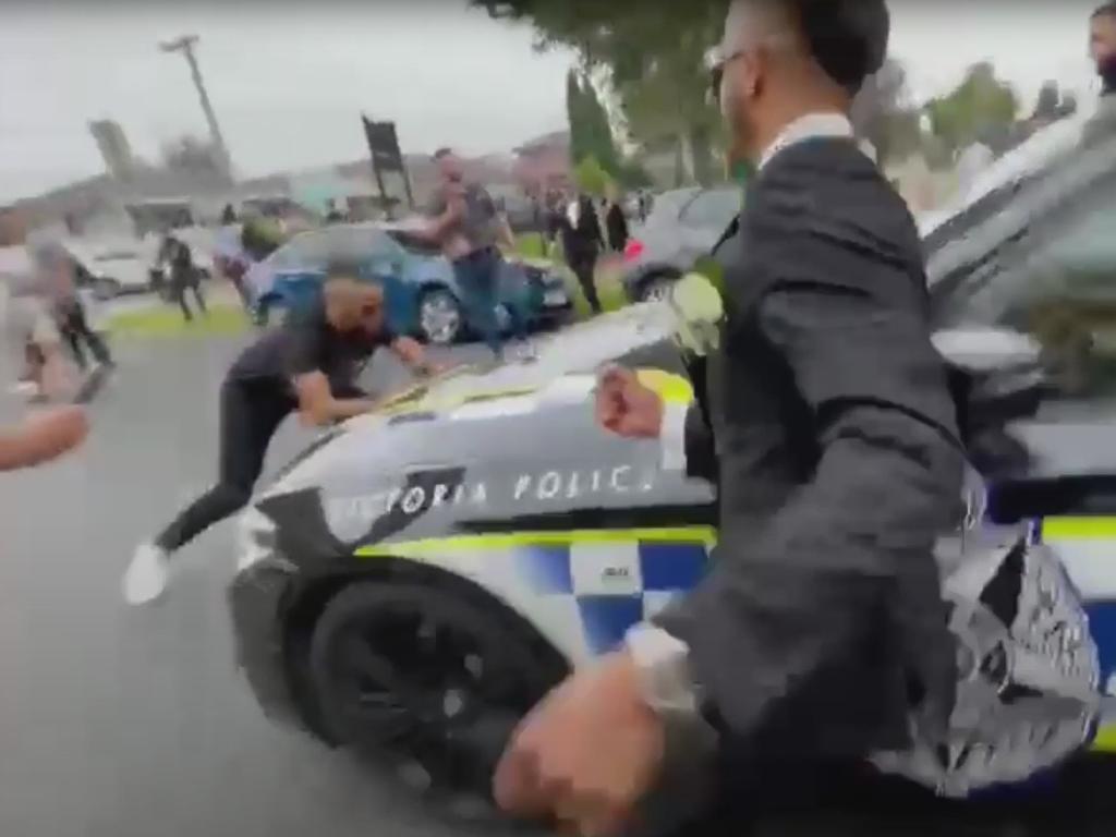 A man in a suit rushes at officers. Source: YouTube