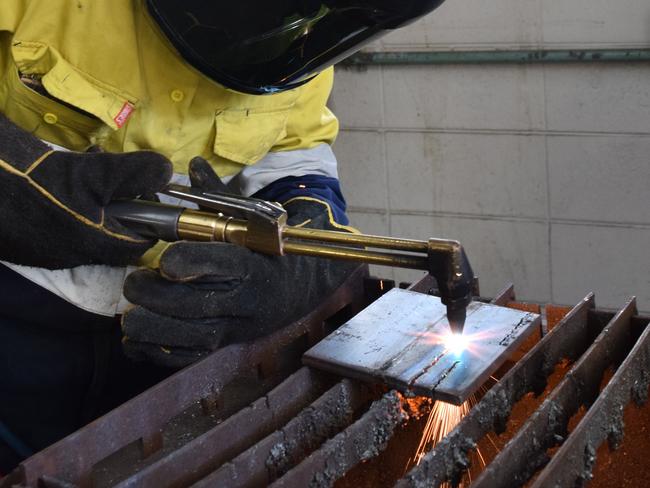 FIRED UP: Apprentice fitter and turner Caitlyn Fleming does some oxy-cutting at the TAFE Queensland East Coast Bundaberg Campus.