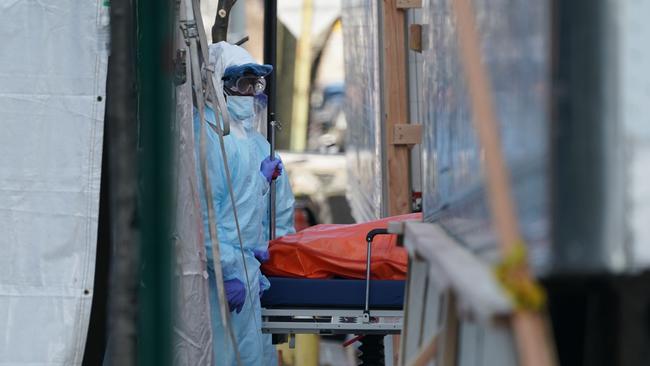 A body is moved to a refrigerator truck serving as a temporary morgue outside New York’s Wyckoff Hospital in Brooklyn on Sunday. Picture: AFP