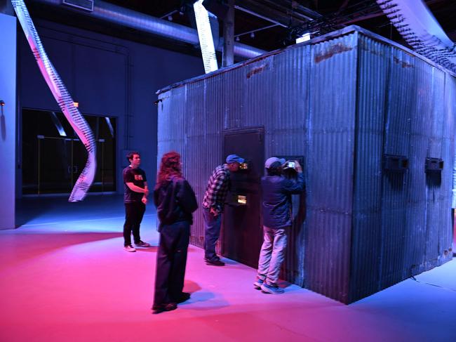Visitors look into a mock prison cell to see artist Nadya Tolokonnikova, co-founder of Pussy Riot, in her 10-day durational piece. Picture: AFP