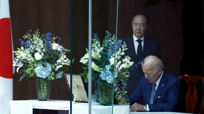 Joe Biden, with Japanese ambassador Koji Tomita, signs a condolence book at the envoy’s residence in Washington on Friday. Picture: AFP