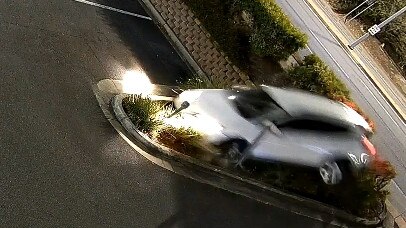 Out of control car airborne as it slams into the garden bed.