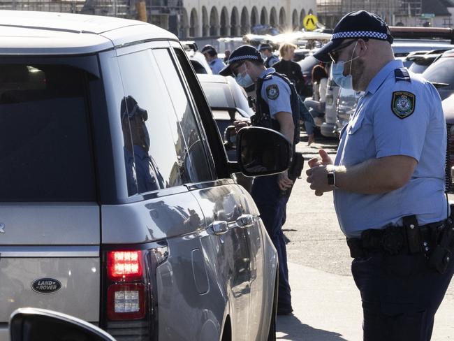 SYDNEY, AUSTRALIA - AUGUST 15: Police conduct public health order compliance checks as people arrive at Bondi Beach on August 15, 2021 in Sydney, Australia. The whole state of New South Wales is now under stay-at-home orders as NSW health authorities work to contain an outbreak of the highly contagious delta COVID-19 strain. From Monday 16 August, the 10km travel rule in Greater Sydney will be reduced to 5km, limiting residents to a 5km radius from their homes. New spot fines for breaching COVID-19 rules will also come into effect including $5000AUD fines for quarantine breaches and $3000AUD for travel breaches.  (Photo by Brook Mitchell/Getty Images)