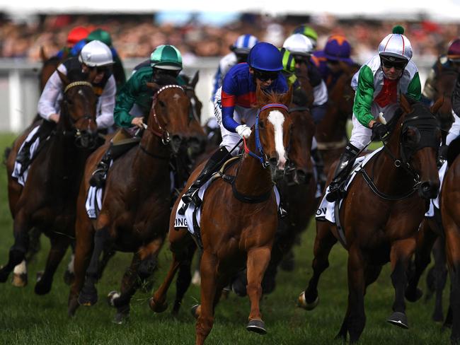 The field sorts itself out as it gallops into the first turn. Picture: AAP