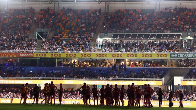 Melbourne and Brisbane players wait after the lights went out at the Gabba. Picture: Getty Images