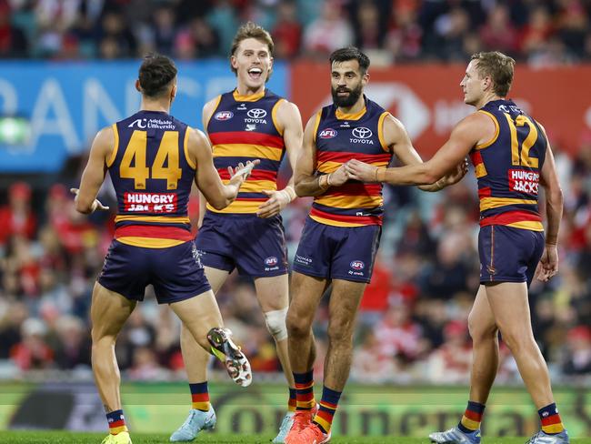 Wayne Milera celebrates a goal with teammates against the Swans.