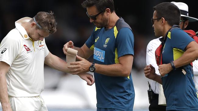 Steve Smith of Australia has his arm strapped by Australian Team Physiotherapist David Beakley after being struck in the arm