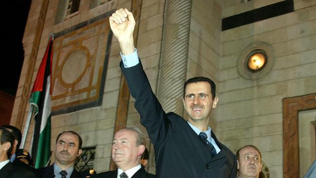 Syrian President Bashar al-Assad waves to people from outside the parliament building in Damascus, March 2005.