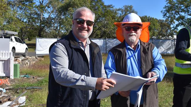 Doug Webber and a council officer look over plans for construction.