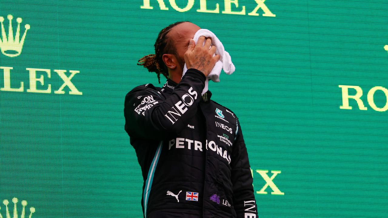 BUDAPEST, HUNGARY - AUGUST 01: Third placed Lewis Hamilton of Great Britain and Mercedes GP wipes his face on the podium during the F1 Grand Prix of Hungary at Hungaroring on August 01, 2021 in Budapest, Hungary. (Photo by Florion Goga - Pool/Getty Images)