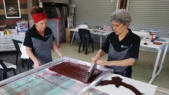 The entire town of Yarrabah are getting behind the Seahawks senior rugby league team, who will compete in this week's CDRL A Grade grand final match against the Innisfail Brothers Leprechauns. Karen Charlebois and Hannah Parker screen print some Seahawks supporters’ banners at the Yarrabah Arts Centre. Picture: Brendan Radke