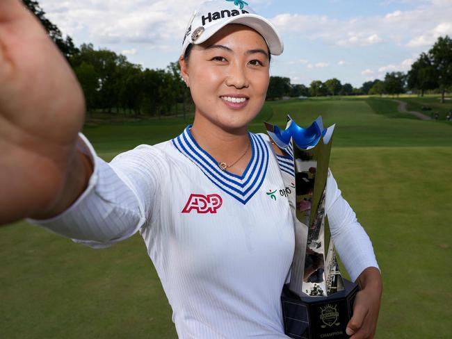 CINCINNATI, OHIO - SEPTEMBER 10: Minjee Lee of Australia imitates a selfie as she poses with the trophy after winning in a two-hole playoff against Charley Hull (not pictured) of England during the final round of the Kroger Queen City Championship presented by P&G at Kenwood Country Club on September 10, 2023 in Cincinnati, Ohio.   Dylan Buell/Getty Images/AFP (Photo by Dylan Buell / GETTY IMAGES NORTH AMERICA / Getty Images via AFP)