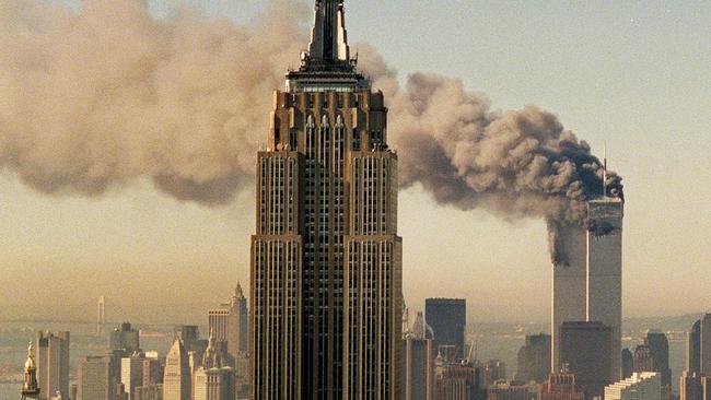 The twin towers of the World Trade Center burn behind the Empire State Building.