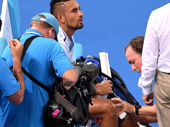 Nick Kyrgios of Australia has his knee strapped in the first set of the Men's final against Ryan Harrison