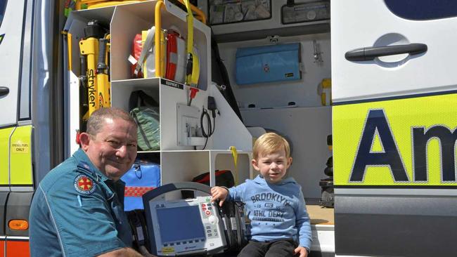 STAY SAFE: Queensland Ambulance Service paramedics, like Derrick Scheuer who showed Max Richter emergency equipment, urges families to stay safe these school holidays. Picture: Sean White