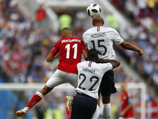Denmark's Martin Braithwaite, left leaps for the ball with France's Steven Nzonzi. Pic: AP