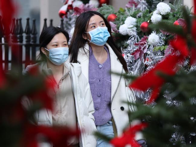 Shoppers wearing face coverings to combat the spread of the coronavirus walk through the Christmas decorations in London. Picture: AFP