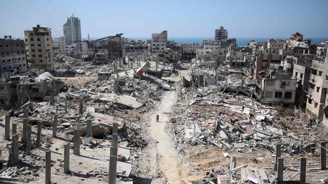 A man pushes a bicycle through the rubble in the devastated area around Gaza's Al-Shifa hospital this week. Picture: AFP