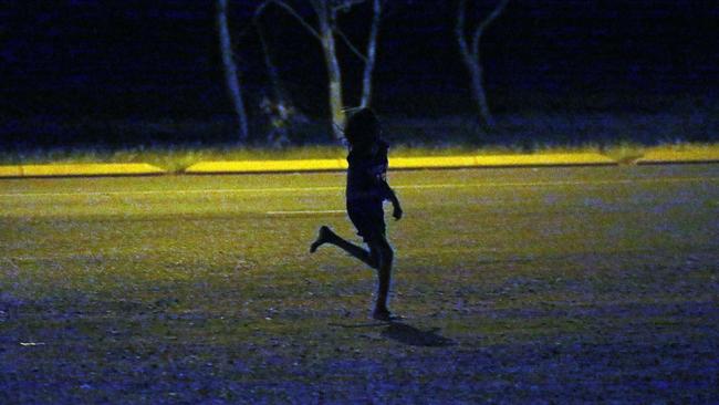 A young girl runs past a petrol station in Tennant Creek last year. Picture Gary Ramage