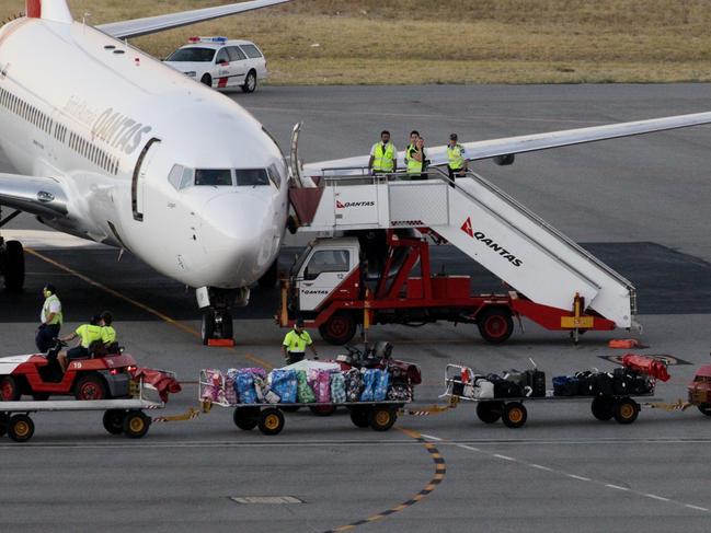 Asylum seekers arrive in Perth on a QANTAS flight from Christmas Island on route to an unknown domestic destination