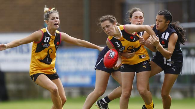 Hayley Monk gets the ball despite the attention of two Falcons defenders.