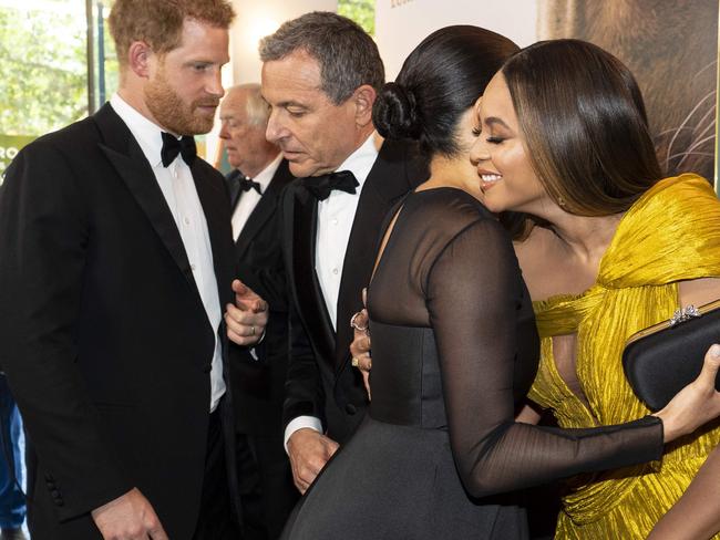 Britain's Prince Harry, Duke of Sussex (L) chats with Disney CEO Robert Iger as Britain's Meghan, Duchess of Sussex (2nd R) embraces US singer-songwriter Beyoncé (R) as they attend the European premiere of the film The Lion King in London on July 14, 2019. (Photo by Niklas HALLE'N / POOL / AFP)