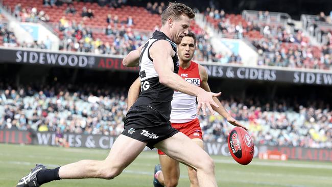 Port Adelaide’s Tom Jonas kicks as Sydney’s Josh Kennedy closes in. Picture: SARAH REED