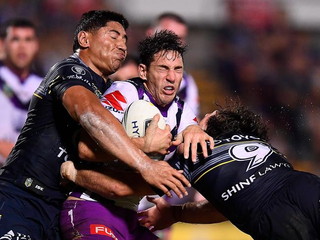 Billy Slater is tackled by Jason Taumalolo.