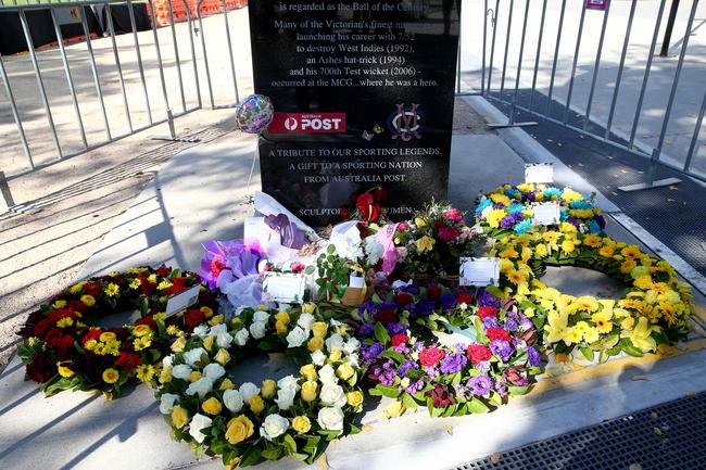 Tributes are left at the base of a statue of late Australian cricket legend Shane Warne