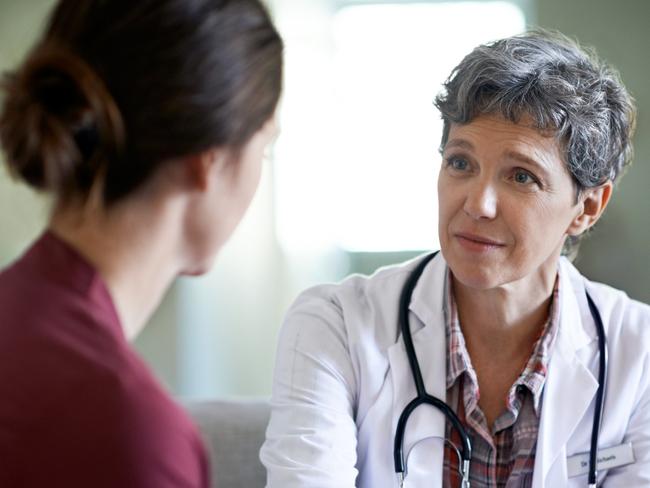 Shot of a compassionate doctor comforting a young woman in a hospital waiting room; fear health scare generic