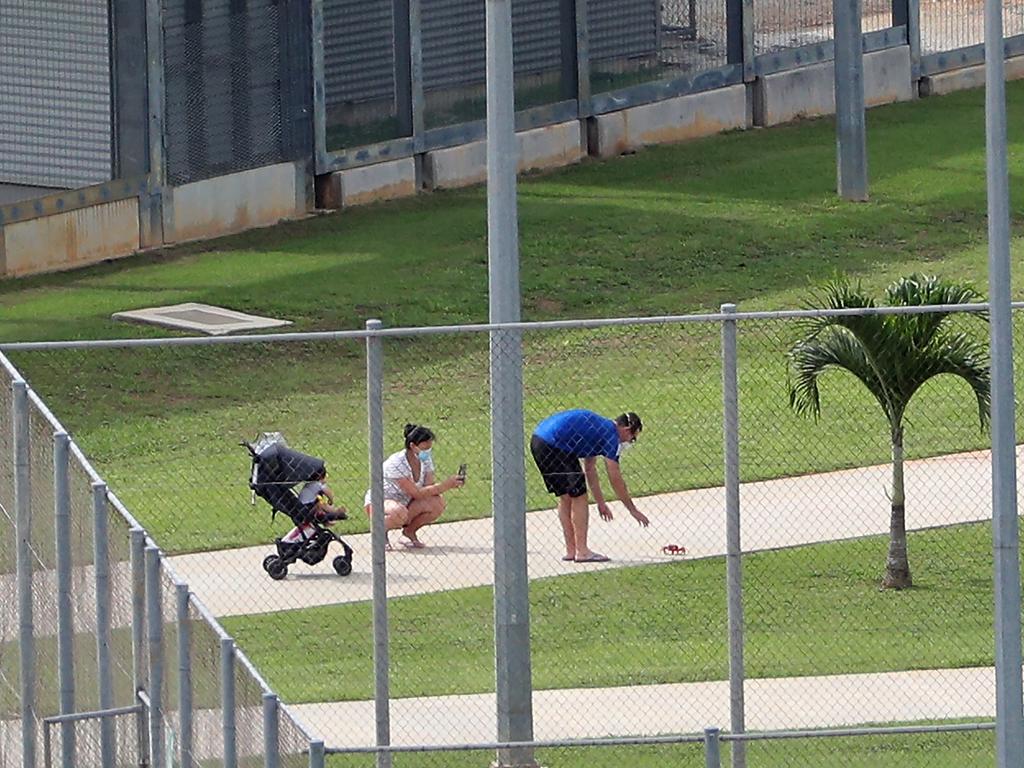 A family of evacuees take a picture of a red crab, commonly found throughout Christmas Island, while in Quarantine. Picture: AAP Image/Richard Wainwright.