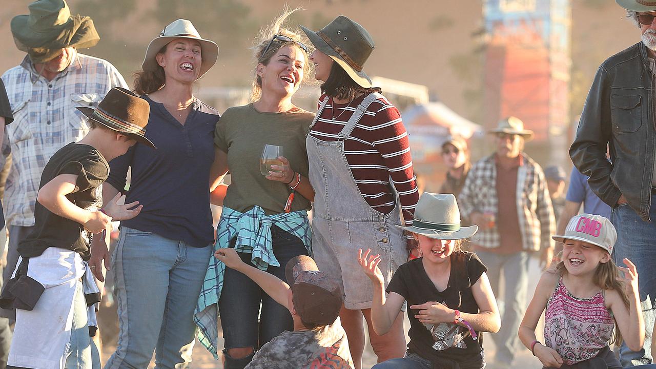 (L-R) Kylie Nolan, Shae Strong and Jess Meuleners with their kids, all from the Sunshine Coast, enjoy the relaxed atmosphere at the Big Red Bash. “It’s like you live on another planet ... the energy is great. It’s a beautiful family vibe,” Ms Strong said. Picture: Lyndon Mechielsen/The Australian