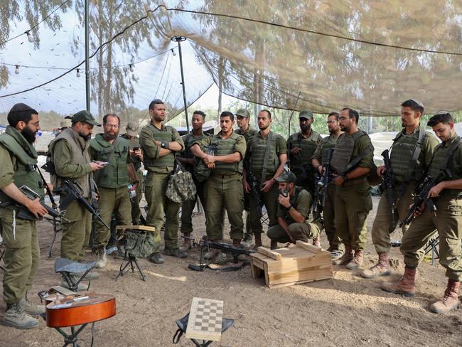 Israeli troops gather near the border with Gaza before entering the Palestinian strip. Picture: AFP