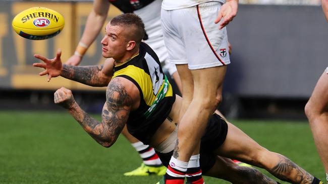 Dustin Martin handballs as he is falling to ground. Pic: Michael Klein