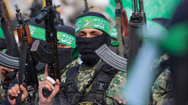 Hamas fighters secure an area in Gaza City on Saturday during the transfer of hostages to the Red Cross. Picture: AFP