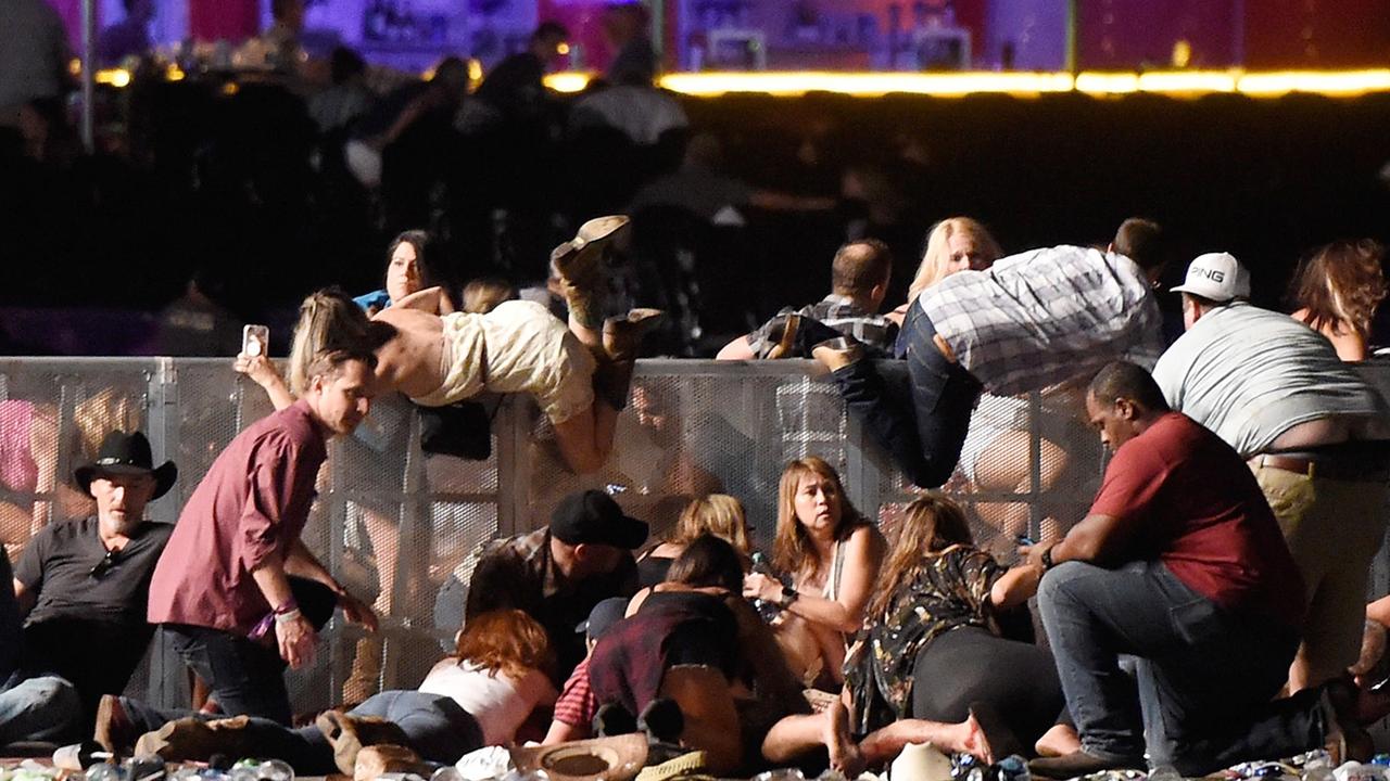 Music fans try to scramble over a barrier at the Route 91 Harvest Festival. Picture: David Becker