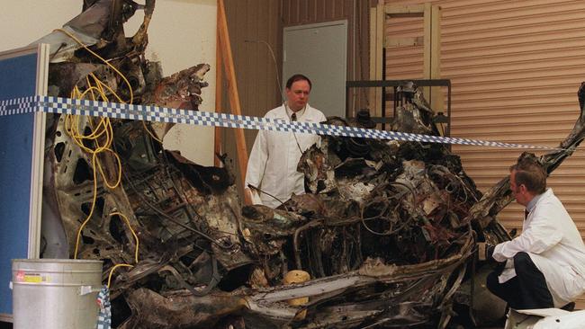 07/08/1998. Wreckage of the bombed car at the Macleod Victorian Forensic Science Centre. Police fire and explosive experts inspect the wreckage of the White Subaru belonging to John Furlan. Furlan was killed in the explosion at Merlynston / Coburg. bombs. murder. PUBLISHED DHS 25 SEPTEMBER 2002.