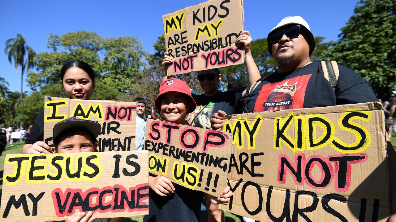 A family holds signs as people gather for the Brisbane protest. Picture: NCA NewsWire/Dan Peled