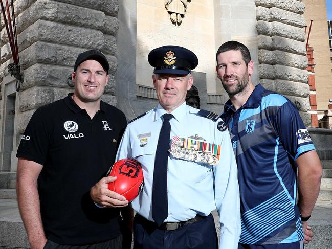 Port coach Matthew Lokan and Sturt coach Marty Mattner with Squadron Leader Peter Nelson and  who will toss the coin on Wednesday's Anzac Day match. Pictured at Adelaide War Memorial. Picture: DYLAN COKER