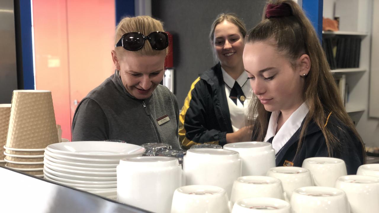 Queensland College of Wine Tourism’s Kim Gallaway teaches St Joseph's College students Sophie Locke (left) and Keeley Hudson the tricks of the trade.