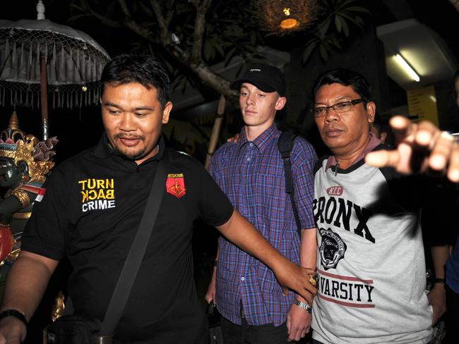 Australian Jamie Murphy is escorted by police during his release at a police station in Kuta on Indonesia's resort island of Bali on November 23, 2016. Picture: AFP PHOTO / SONNY TUMBELAKA