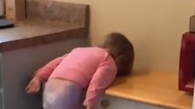 The hilarious moment a mum caught her toddler swinging gently from a table has been caught on camera.