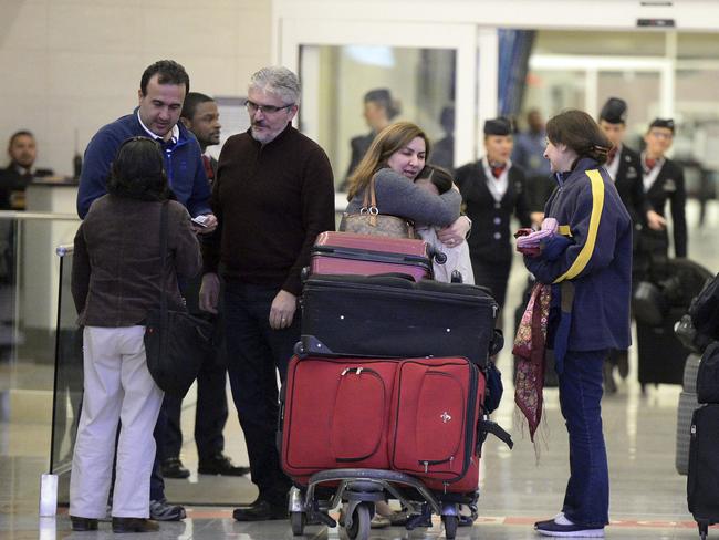 Mansour Kenereh (centre) reunites with family members in the International arrivals lobby at Hartsfield- Jackson International Airport on Saturday in Atlanta. The family of three were among several people detained at the US Customs and Border Protection office following an executive order from President Donald Trump limiting immigration. Picture: Kent D. Johnson/Atlanta Journal-Constitution via AP