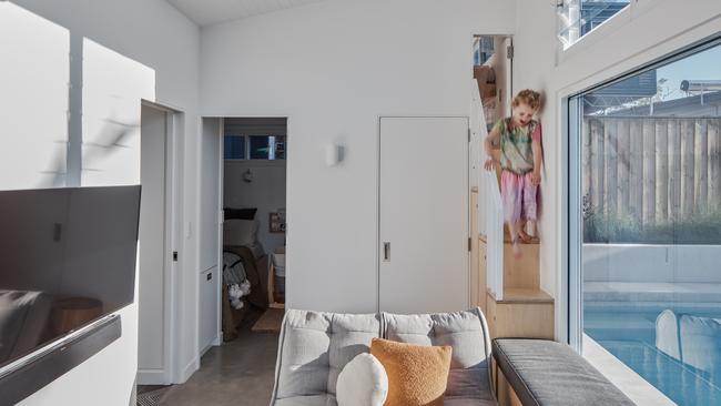 A loft-style bedroom is accessed via a compact staircase